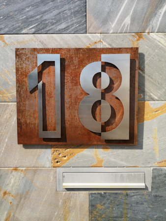 Number 18 in silver pain on iron background for house or building portal.の写真素材