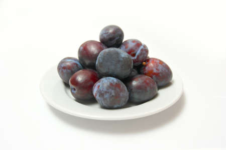 Plums on white plate の写真素材