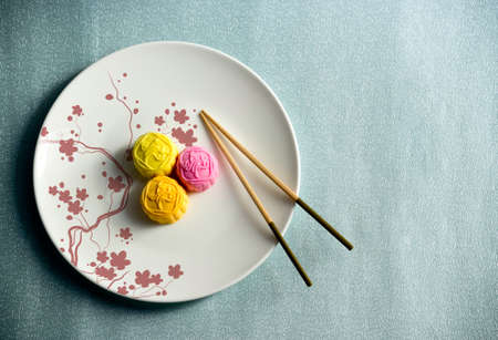 moon cake on a white plate and chopsticks