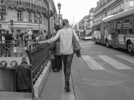 Paris, France - Sept 2015: A woman walking on street next to Metro entranceのeditorial素材