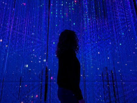 A lady posing at Epson Team Labs digital art museum against blue led lights creating a silouhette