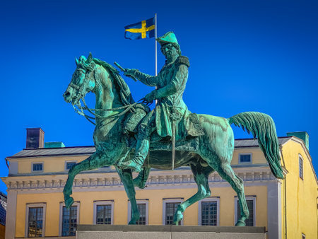 A statue of man and horse with Swedish flag in backgroundのeditorial素材