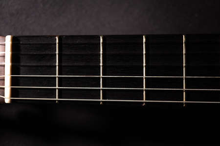 Classical guitar on black background. Acoustic guitar concept.Perfect for flyer, card, poster or wallpaperの写真素材