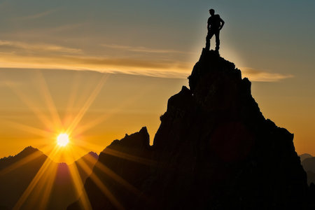 A man on top of a  mountain  with the sun setting behind him. Generative Aiの素材