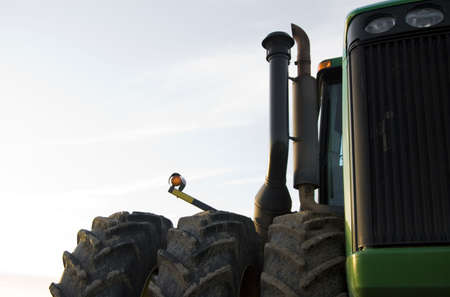 Large agricultural tractor lit by warm dusk sun.の写真素材