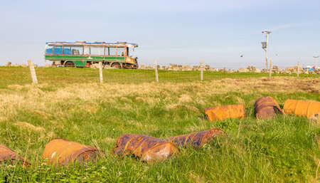 Derelict bus in the Outer Hebrides, with oil drumsの写真素材