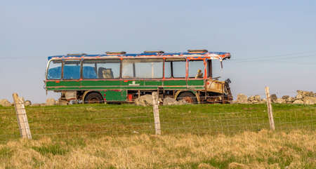 Derelict green bus on a hillの写真素材