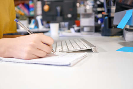 Woman female hands with pen writing on notebook at home or officeの写真素材