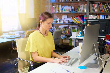 a serious businesswoman using laptop in officeの写真素材