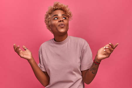 Sensual african young woman with posing with surprised facial expression and looking up, emotional...
