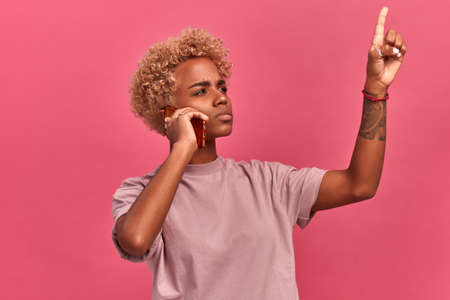 Young dark skinned female listens intently to someone on the smart phone and makes an important...
