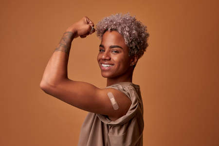 Happy African Woman Flexing Arm After Vaccination For Coronavirus Protection