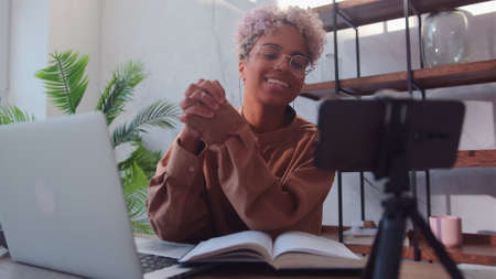 Young friendly African American woman is recording her video blog.