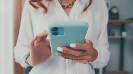 Close up of Caucasian woman hold cellphone typing message using internetの写真素材