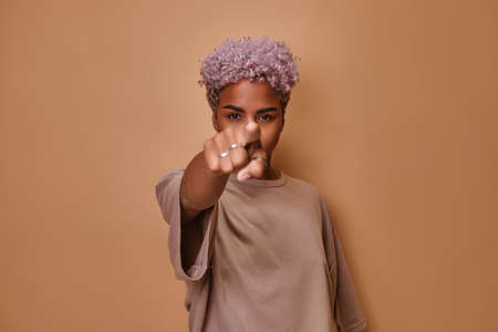 Young African American woman looks directly at screen and points finger on youの写真素材