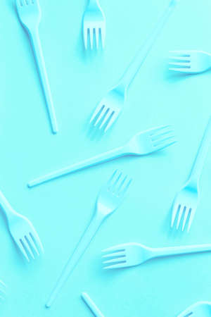 Bright neon forks on blue light background can be used as a design of children's menu. Fast food concept.の写真素材