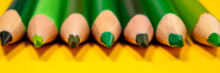Vibrant banner with green sharpener pencils on yellow background. Education, business and writing concept. Selective focus. Banner template.の写真素材