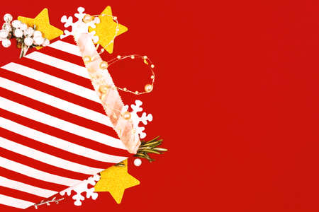 Amazing red Christmas composition. Top view of Traditional striped christmas gift bag with garland. Snowflakes and stars create festive mood.の写真素材
