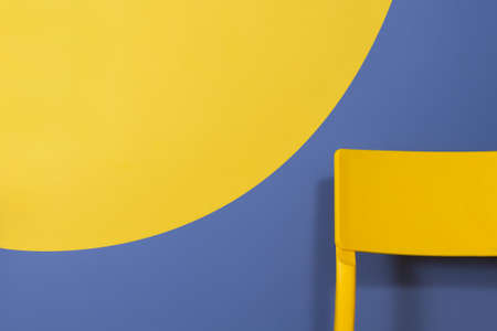 Conceptual modern color block interior design. Yellow trendy chair and colored circle on blue wall. Office Interior Design Option.の写真素材
