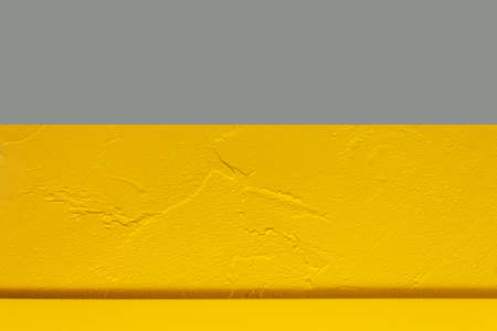 Yellow and grey concrete wall as texture or background. Geometric style. Plastered surface. Good-quality walls painting.の写真素材