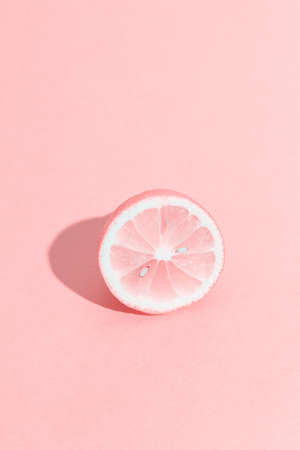 Slice of lemon with bones. Summer, youth, freshness concept. Funny pink monochrome citrus. Vertical format.の写真素材