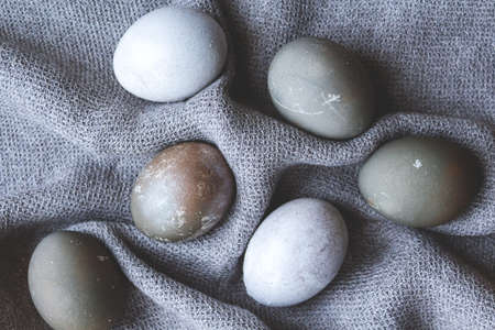 Amazing painted easter eggs. Gray and blue eggs on gray knitted napkin. Cozy Easter at home. Open...