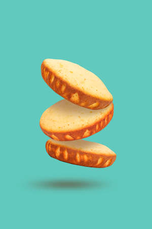 Culinary baking concept with levitation effect on soft mint background. Sponge vanilla cakes hanging in air.の写真素材
