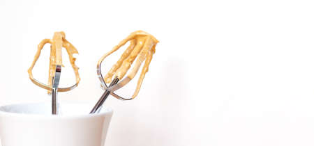 Close-up of coffee cream on metal whisk on light background for dalgona coffee. Copy space. Culinary...