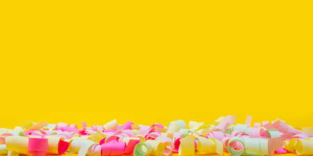 Multicolored festive funny serpentine on bright yellow background. Kid's holiday or invitation...
