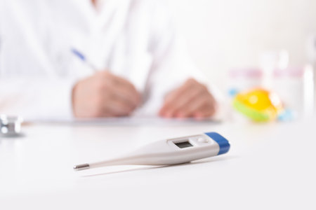 Pediatrician neonatologist writes pills prescription or diagnosis during visit in clinic ....