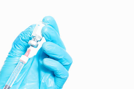 Hands in blue protective medicine gloves. Doctor or nurse filling medicine from ampoule into...