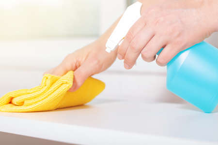 Blue chlorine bottle spray. Woman using detergent and wipe. Cleaning with cleanser spray. Cleaning house services. Quality housekeeping. Close-up.の写真素材