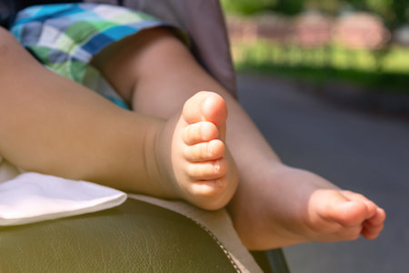 Naked caucasian baby feet in stroller. Close-up.の写真素材