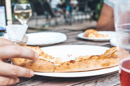 Woman takes slice of pizza in restaurant.の写真素材