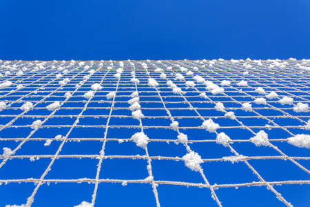 Volleyball net covered with snow. Natures minimalism.の写真素材