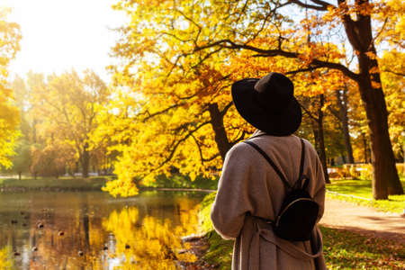 Woman in hat in park. Back view.
