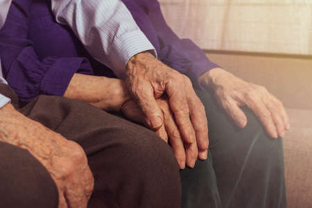 Grandfather holding grandmothers hand. Support and care.の写真素材