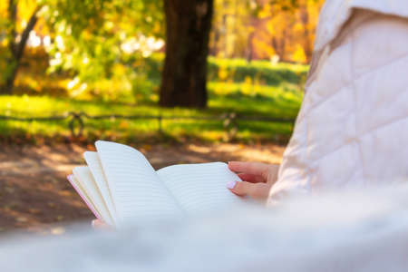 Woman reading book in park. Autumn mood.の写真素材