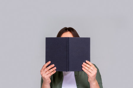 Caucasian unrecognizable woman hiding behind day planner.の写真素材