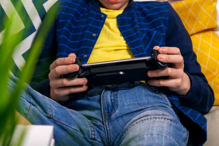 Unrecognizable caucasian teenager playing phone with console. Joystick for cell phone. Entertainment...