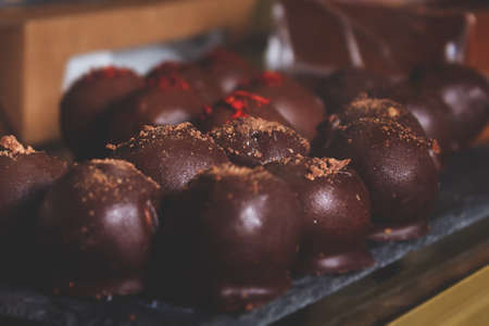 Cheese candies in chocolate coating on counter. Handmade chocolates with different decorations .の写真素材