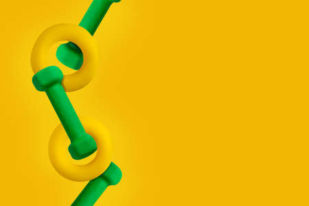 Sport yellow background. Expander and dumbbells. Copy space. Levitation. Sport left border. Easy to transform to banner format.の写真素材