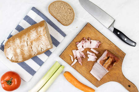 Flatlay above served sliced bacon with bread tomato leak and carrot on the grey marble table.の写真素材