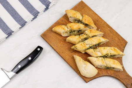 Baked and sliced bruschetta bread with garlic and spices served on the wooden board.
