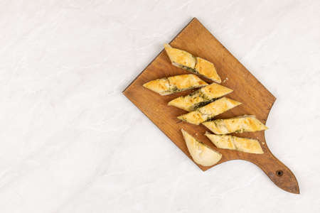 Baked and sliced bruschetta bread with garlic and spices served on the wooden board with copy space.