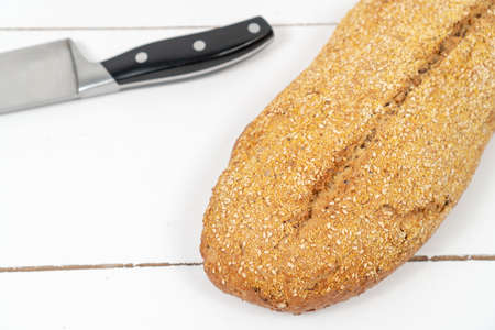 Whole Bread With Sesame Seeds On The Wooden Table.