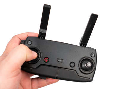 Drone controller with antennas in the hand above white background.