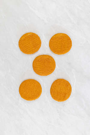 Round Fishcakes arranged on the grey marble table background.