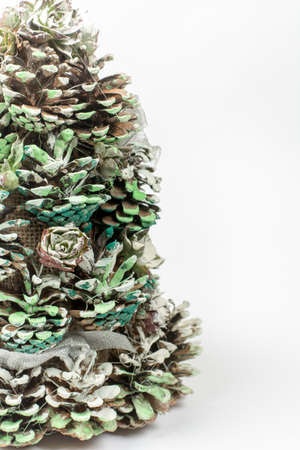 Christmas tree made of pinecones over white background with copy space