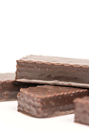 Chocolate wafers stacked over white background with copy space